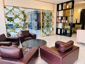 锡卜Golden Crown Hotel Alseeb Muscat的大堂设有皮椅和桌子