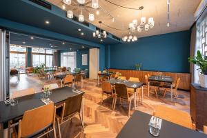 维也纳magdas HOTEL Vienna City - First Social Business HOTEL in Austria的一间带桌椅和蓝色墙壁的餐厅