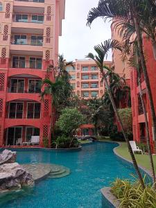 乔木提恩海滩Seven Seas Condo Resort Beautiful Location的棕榈树建筑前的游泳池