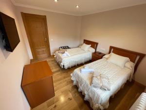 La GandaraLa Casona El Carrascal的小房间设有两张床和电视