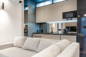 耶莱尼亚古拉Apartament Blue Moon的一间带白色沙发的客厅和一间厨房