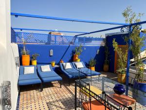 马拉喀什埃尔阿萨别墅酒店的阳台的天井配有蓝色家具和植物