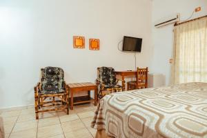 伊瓜苏港帕罗奥罗莎酒店的卧室配有一张床和一张桌子及椅子