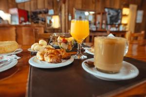 伊瓜苏港帕罗奥罗莎酒店的餐桌,盘子和一杯橙汁