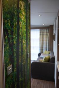 斯特兰达Koie Smart的客厅配有沙发和一幅树木画