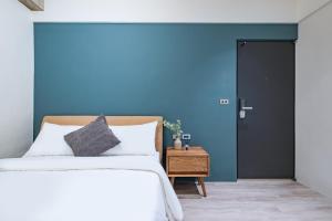 台北Lin Suites by Olala Homes的一间卧室设有一张床和蓝色的墙壁