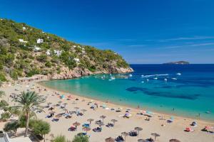 圣胡安包蒂斯塔El Somni Ibiza Dream Hotel by Grupotel的海滩上有遮阳伞和水中的人
