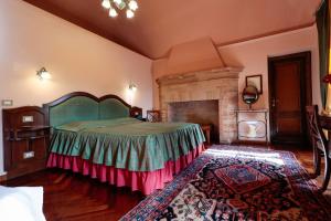 特拉莫Hotel Corte dei Tini的一间卧室设有一张大床和一个壁炉