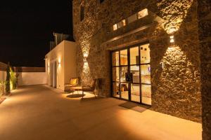 (( Litherés ))Arivallos Villa & SPA with Sauna and Wine Cellar的一座带露台的建筑,晚上有灯光