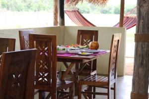 维勒珀图Nirvaan Safari Lodge的一张带椅子的木桌和一盘食物