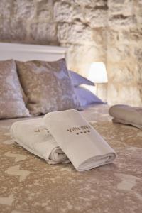 斯普利特斯普利特别墅传承酒店的地板上一张带白色毛巾的床