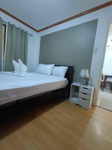 达沃市Alles One Oasis Condo Davao Near SM Mall with Wifi的一间卧室配有一张床和一张带台灯的桌子