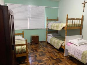 拉热斯Pousada Irmãs Franciscanas的客房设有两张双层床和一扇窗户。
