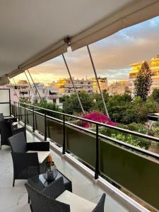 雅典Glyfada Downtown的阳台配有桌椅,享有城市美景。