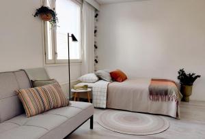 拉赫蒂Beautiful studio in the heart of Lahti的一间卧室配有一张床、一张沙发和一个窗口