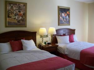 卡门城皇家庄园酒店的酒店客房设有两张床和两盏灯。