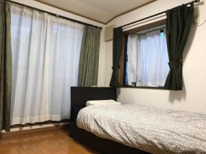 川崎Noriko's Home - Vacation STAY 13624的一间卧室配有床、镜子和窗帘