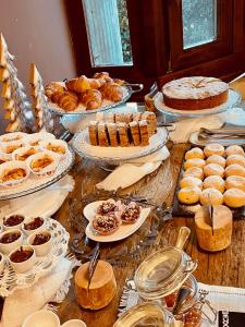 蓬泰迪莱尼奥Hotel Garni Sorriso的一张桌子,上面放着各种糕点和蛋糕及馅饼