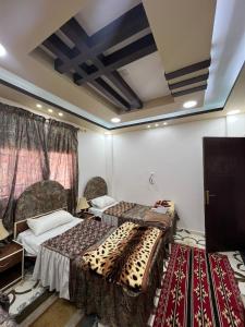 Al ḨayyBeida Bedouin House的一间设有两张床和两张桌子的房间