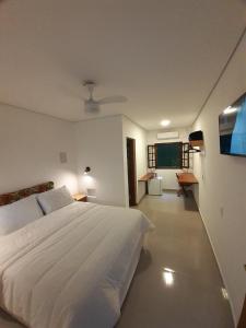 乌巴图巴Caminho da areia的卧室配有白色的床和平面电视。