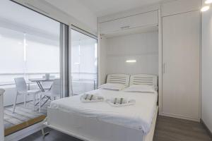 比亚里茨Nice flat with terrace and parking - Biarritz - Welkeys的一间带白色床的卧室和一间用餐室