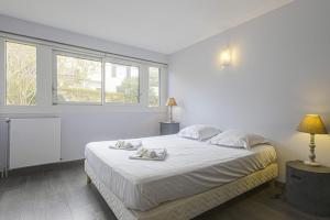 比亚里茨Nice flat with terrace and parking - Biarritz - Welkeys的白色卧室配有带2条毛巾的床