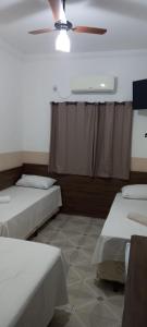 阿帕雷西达Pousada Bela Rainha的客房设有两张床和吊扇。