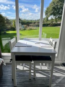 卡林顿The Garden Room - A cosy country stay in Cornwall的门廊上的白色桌椅