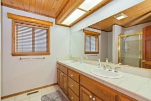 大熊湖CUSTOM SINGLE STORY CABIN WITH JACUZZI POOL TABLE & BIG GAME ROOM WITH ARCADE games的一间带两个盥洗盆和大镜子的浴室