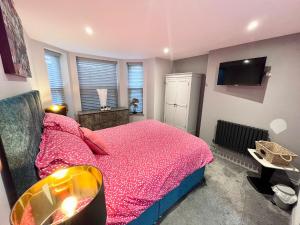 克罗默Olívia Rojo的一间卧室配有粉红色的床和电视