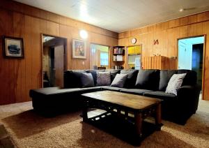 大贝尔城Green Cabin in Big Bear Lake 3 bdr Pets Friendly的客厅配有黑色沙发和咖啡桌