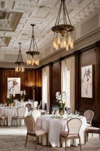 纳什维尔The Hermitage Hotel的用餐室配有桌椅和吊灯。