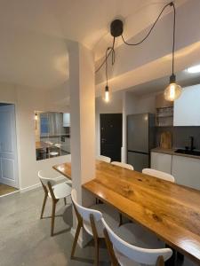 蒂米什瓦拉Apartament Mony的厨房以及带木桌和椅子的用餐室。