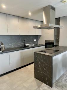 多纳瓦利Apartmány Residence的厨房配有白色橱柜和黑色台面