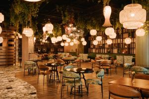 迪拜Sonder Business Bay的餐厅设有桌椅和吊灯。