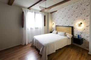 乌贝达Hotel Juancaballo的一间卧室设有一张带花卉墙壁的大床