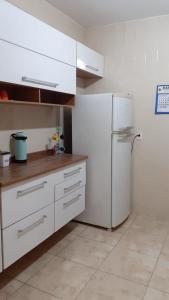 圣维森特岛Apto acochegante com Praia e lazer的厨房配有白色橱柜和冰箱。