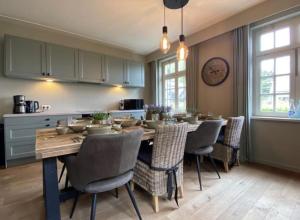 巴尔莱-赫尔托赫Sfeervol landhuis in de groene Kempen的厨房配有餐桌和椅子