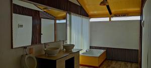 普诺Los Uros Lago Titicaca的浴室配有2个盥洗盆、卫生间和浴缸。