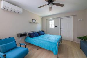 康科德TheCozyCorner in Concord的一间卧室配有一张床、一张沙发和吊扇。