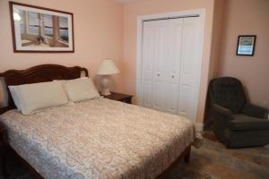 阿兰瑟斯港行政钥匙海滩公寓酒店的一间卧室配有一张床和一把椅子