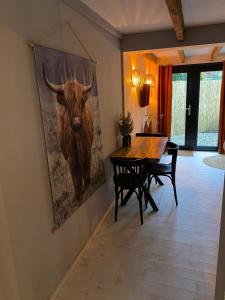 阿森B&B Stoet & Berre Geheel privé 1 - 4 pers的墙上挂着一幅公牛画的饭厅