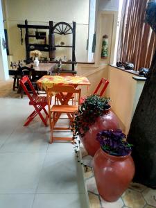 帕尔梅拉斯Pousada Caminhos da Chapada的一间带桌子和两张红色椅子的用餐室