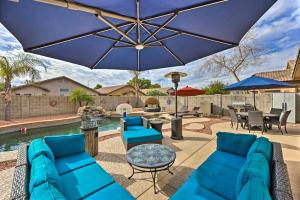 皮奥里亚Radiant Peoria Paradise House with Pool and Patio!的配有蓝色家具和遮阳伞的庭院