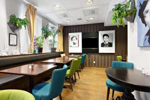 奥克什贝里亚Best Western Hotel Akersberga的一间带桌椅和电视的餐厅