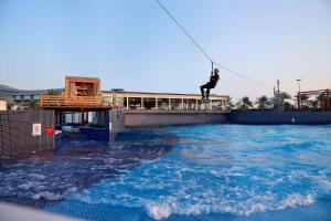 阿布扎比Radisson Blu Hotel & Resort, Abu Dhabi Corniche的水体上空绳索上的人