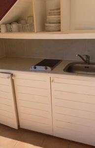 圣安尼Ocean dream的厨房配有白色橱柜和水槽