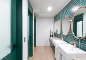 釜山Brosis Hotel的浴室设有2个水槽和2面镜子