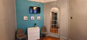 圣地亚哥Hotel Voila Londres的一间设有两把椅子和橱柜的蓝色墙壁客房