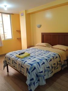 洛哈Hotel Residencial Miraflores的一间卧室配有一张带蓝色和白色棉被的床